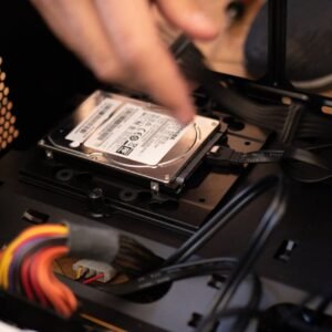 Hands installing a hard drive in a computer case, emphasizing technology and connectivity.